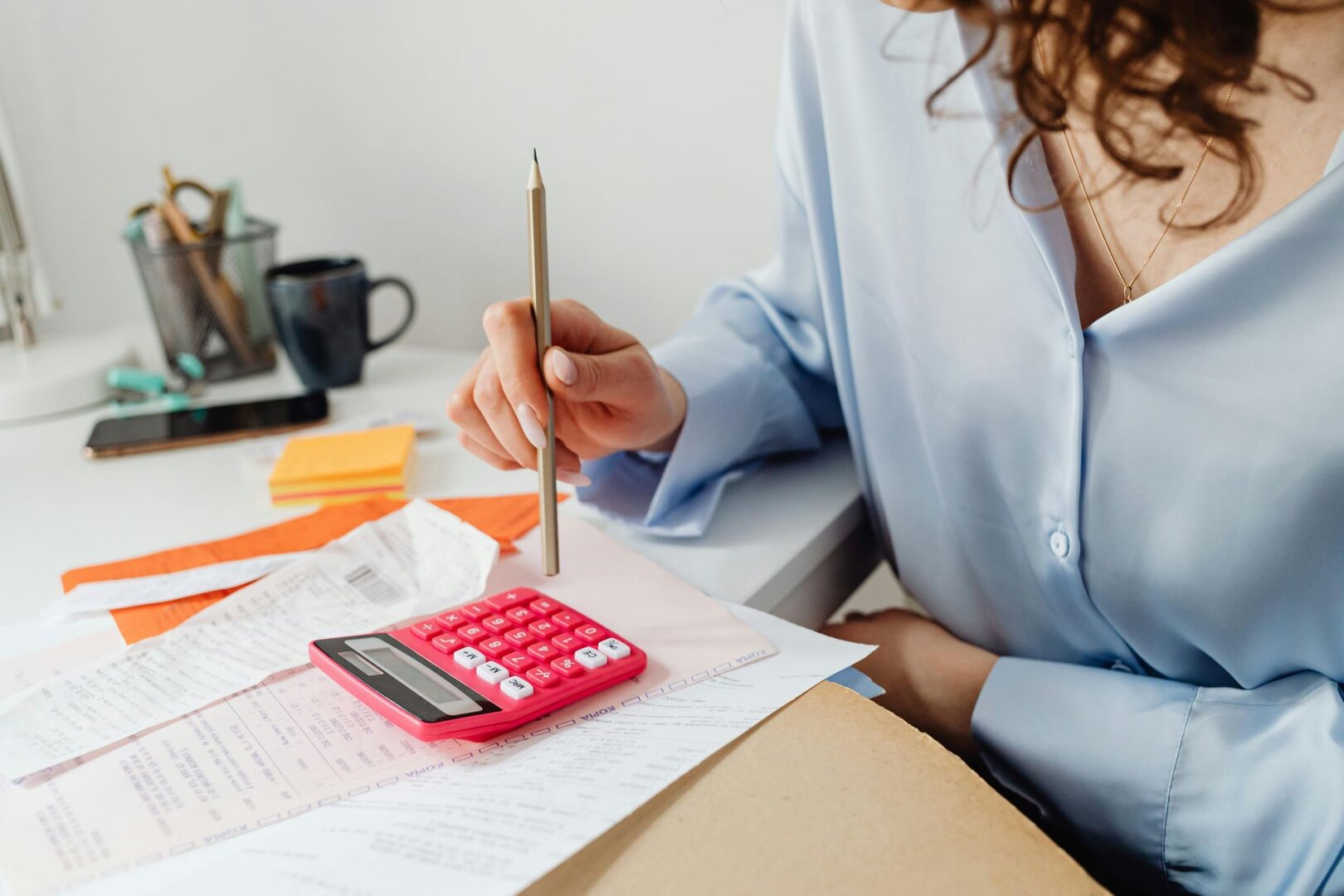 Frau arbeitet mit Taschenrechner und Bleistift 