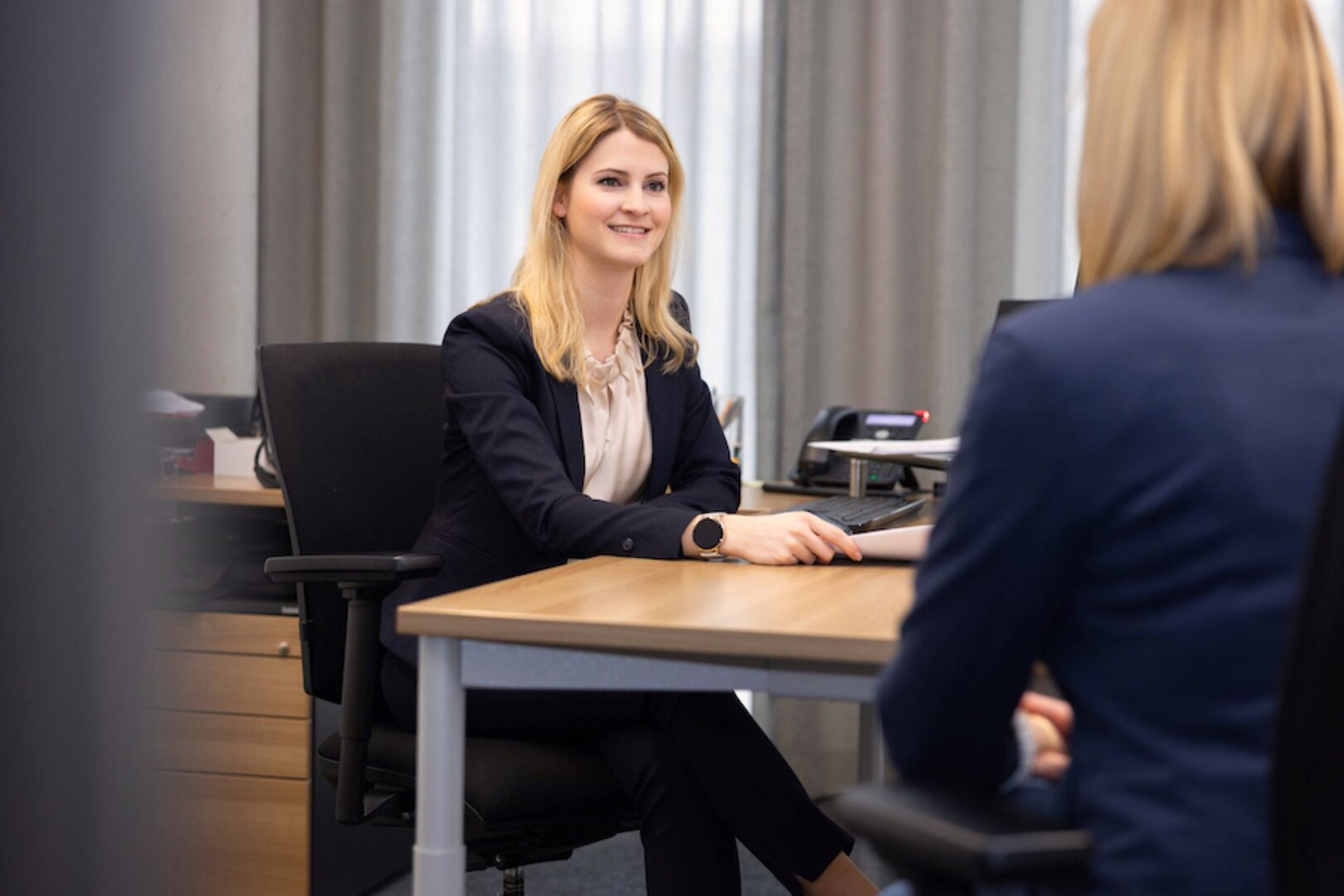 Frau sitzt an Schreibtisch, Tipps für Zusammenarbeit mit Personalvermittlungen